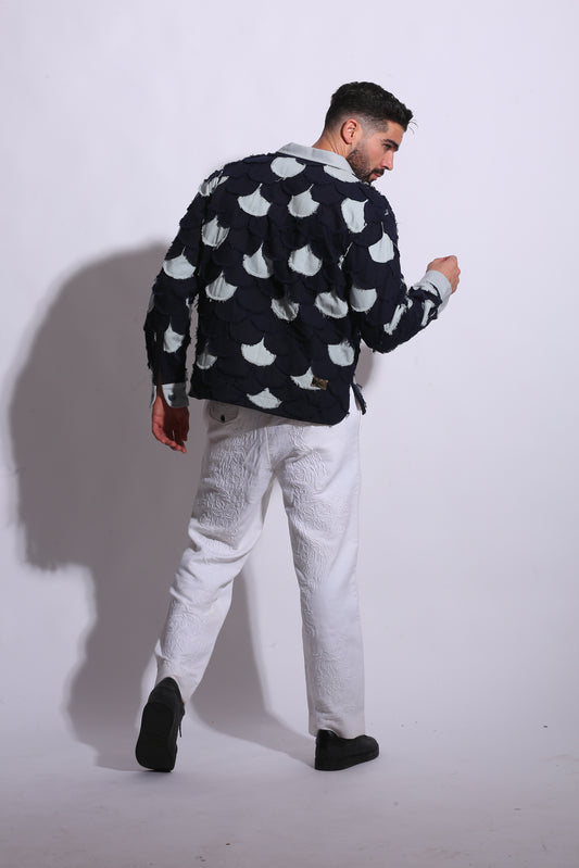 Person wearing a black jacket with white patterns on a white background