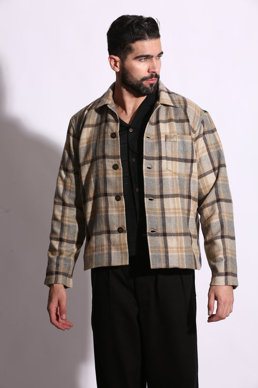 Man wearing a plaid jacket over a black shirt on a white background