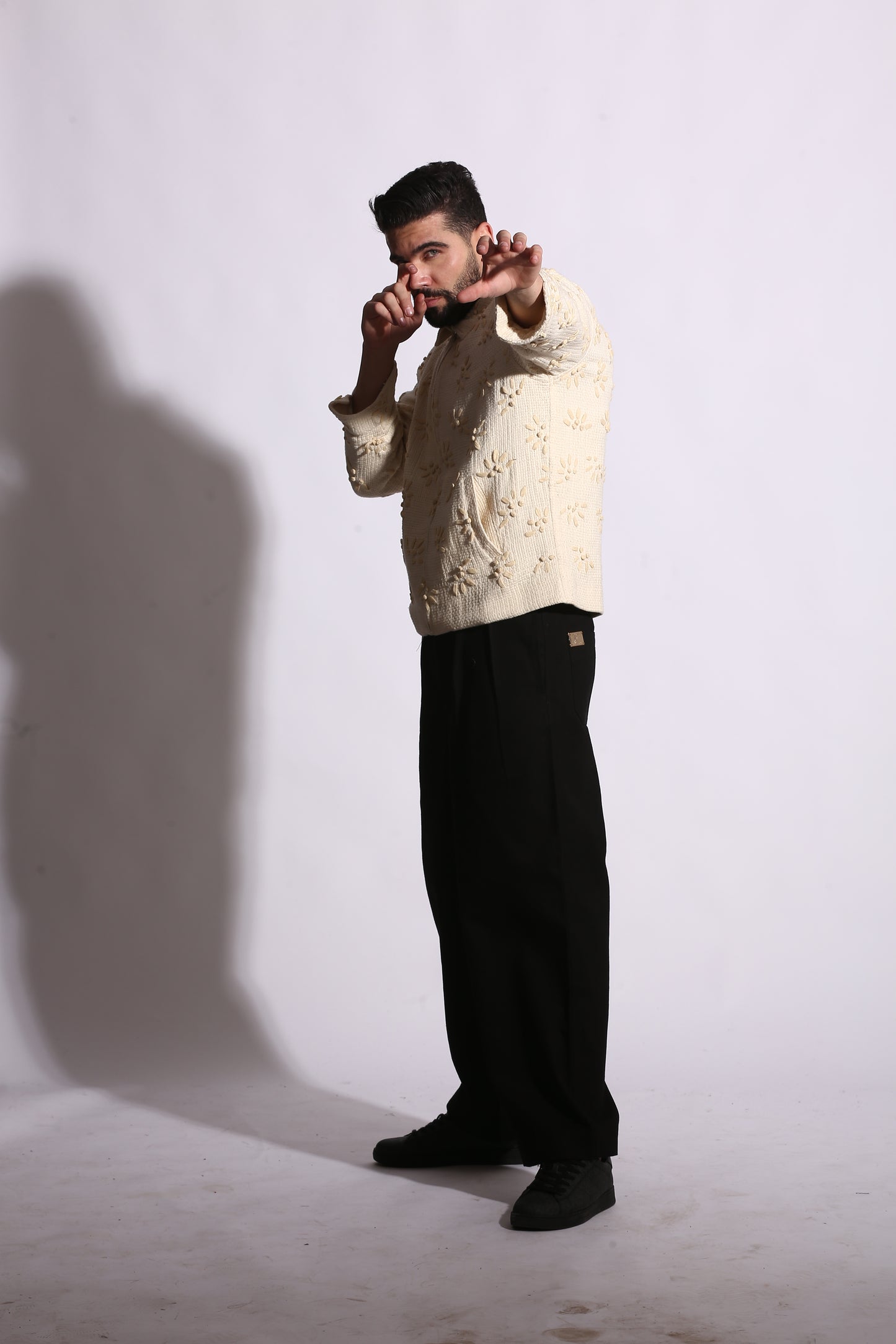 Person wearing a white shirt and black pants on a white background