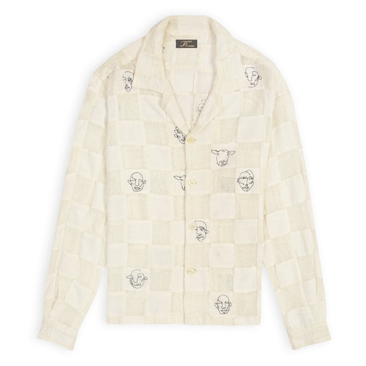 An off-white patchwork shirt with artistic face doodles on a casual collar and sleeve design.