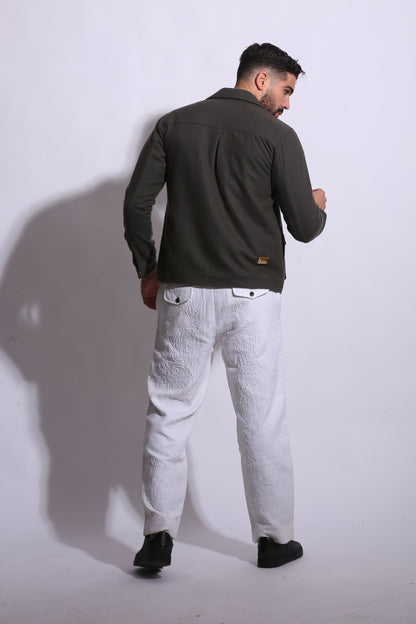 Person wearing a dark jacket and light pants on a white background