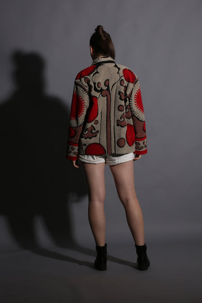 Person wearing a patterned coat on a plain background