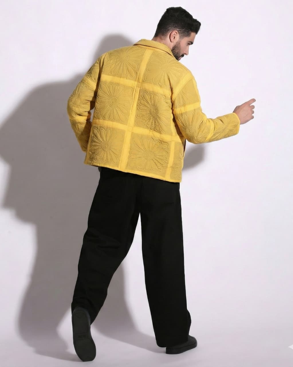 Person wearing a yellow jacket with a grid pattern on a white background